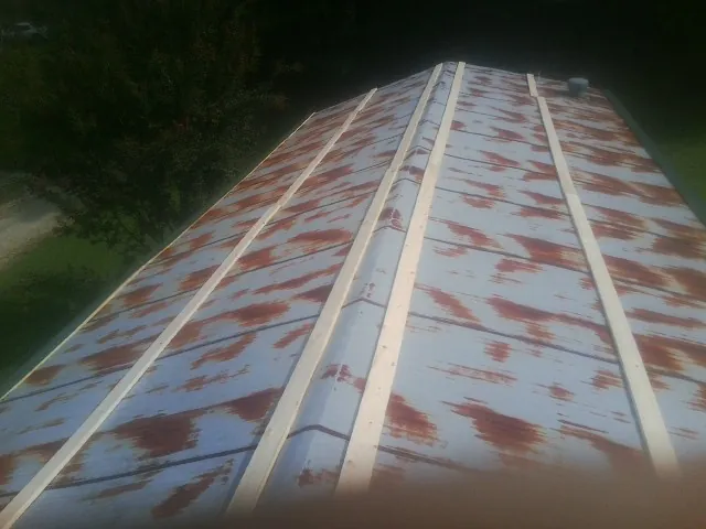 Rusted metal roof panels with new wood purlins before replacement — Storm Damage Roof Repair in Albion by Roofing Brothers